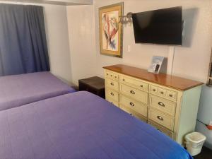 een slaapkamer met 2 bedden en een dressoir met een flatscreen-tv bij Ocean Walk Resort - Remarkable Ocean Front View in Daytona Beach +37 foto's