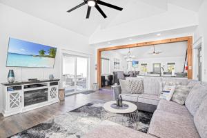 ein Wohnzimmer mit Sofa und Fernseher in der Unterkunft Amazing Sunset Lake Views, Huge Deck & Hot Tub! in Sunrise Beach