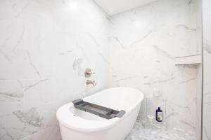 ein weißes Badezimmer mit Toilette und weißen Marmorwänden in der Unterkunft Amazing Sunset Lake Views, Huge Deck & Hot Tub! in Sunrise Beach + 74 Fotos