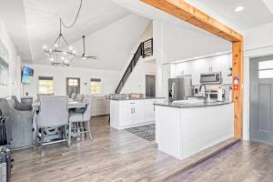 eine Küche mit weißen Schränken und einem Tisch mit Stühlen in der Unterkunft Amazing Sunset Lake Views, Huge Deck & Hot Tub! in Sunrise Beach