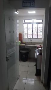 a bathroom with a sink and a window at Pousada El Shaday compartilhada in Barueri