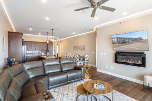 a living room with a leather couch and a fireplace at Brand New Complex, Central Location, Amazing Views in Laguna Beach