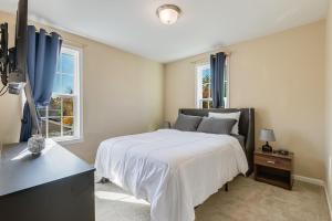 a bedroom with a large bed and two windows at Entire Home in Lanham MD in Lanham
