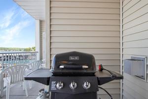 a grill on a patio with a table and chairs at Experience Lakeside Living at Its Finest: Stunning Views and Prime Location! in Laguna Beach