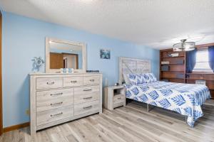 ein Schlafzimmer mit einem Bett, einer Kommode und einem Spiegel in der Unterkunft Amazing Dock Fishing with Swim Area & Gentle Lot in Buck Creek