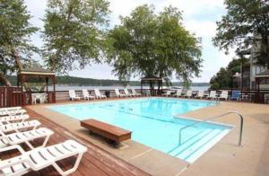 a large swimming pool with white chairs and a table at Dream Condo with Perfect Location for All The Fun! in Damsel