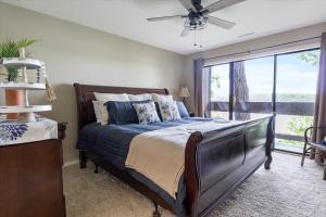 ein Schlafzimmer mit einem Bett und einem großen Fenster in der Unterkunft Excellent Family Stay w/ Boat Slip, 2 Pools, Hot Tub, Courts & Arcade Games in Damsel + 38 Fotos