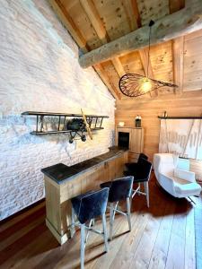 CharchillaにあるGîte Les Plaisirs du Lac avec spa & jacuzziの石壁のリビングルーム(シャンデリア付)