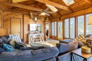 ein Wohnzimmer mit Sofas und einem Deckenventilator in der Unterkunft Firepit, Kayaks, Paddle Board, Lake Views, Great Location in Purvis