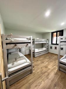 CharchillaにあるGîte Les Plaisirs du Lac avec spa & jacuzziのウッドフロアのドミトリールーム 二段ベッド3台