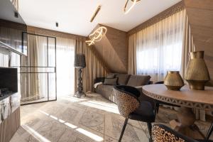 a living room with a couch and a table at Willa Tatrzańska Luxury Apartments & Spa in Murzasichle