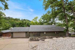 ein Gewächshaus mit Garage und Bäumen in der Unterkunft Game Room, Dock Life, Fire Pit & Hot Tub! in Four Seasons