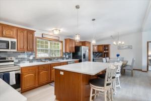 eine Küche mit Holzschränken und einer weißen Arbeitsplatte in der Unterkunft Gentle Sloped Lot, Private Dock, Boat Slip, Kayaks, Fire Table, Lakeview Deck, Family Friendly in Purvis