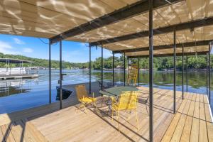 ein Haus auf einem Steg mit einem Tisch und Stühlen in der Unterkunft Firepit, Kayaks, Paddle Board, Lake Views, Great Location in Purvis