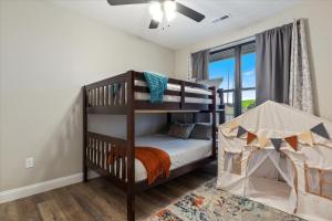 a bedroom with two bunk beds and a window at Family-Fun Lakeside Luxury at Topsider in Osage w/ 2 Pools, Prime Views Pack N' Play & Games in Laguna Beach +46 photos