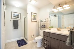 a bathroom with a sink and a toilet and a mirror at Close to The Strip, Private Dock & Screened Deck! in Lake Ozark +43 photos