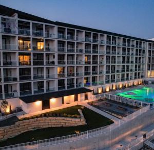 a large building with a swimming pool in front of it at Family-Fun Lakeside Luxury at Topsider in Osage w/ 2 Pools, Prime Views Pack N' Play & Games in Laguna Beach