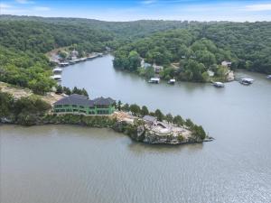 an aerial view of a house on an island in the water at Expansive Lakefront Estate with Private Pool & Movie Theater at 43mm in Purvis