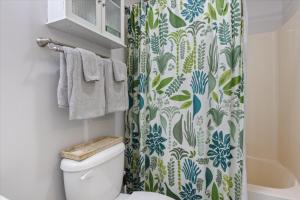 Un baño con cortina de ducha y un inodoro. en Amazing Wall of Windows, Swim Dock & Pet Friendly, en Arrowhead Beach 64 fotos más