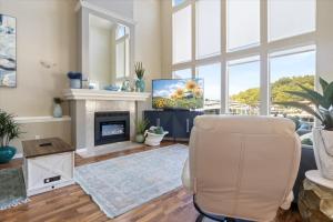 Una sala de estar con una silla y una chimenea. en Amazing Wall of Windows, Swim Dock & Pet Friendly, en Arrowhead Beach