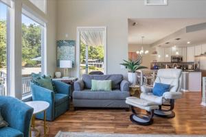 sala de estar con muebles azules y cocina en Amazing Wall of Windows, Swim Dock & Pet Friendly, en Arrowhead Beach