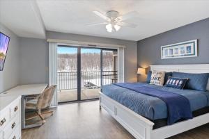 a bedroom with a bed with a ceiling fan and a balcony at Family Fun at Lake Vibin' Lazy Days Osage Beach w/ 2 Pools, Playground, Games & Calm Water in Damsel +66 photos