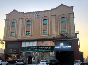 a large building with cars parked in front of it at شقق اوبين المخدومة الدمام Open in Dammam