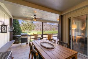 a screened in porch with a wooden table and chairs at Lakeside Living at Hound Ears in Valle Crucis