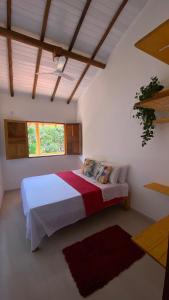 a bedroom with a bed in a room with a window at Kitnets ESPELHO a 160 metros da Praia do Espelho in Praia do Espelho