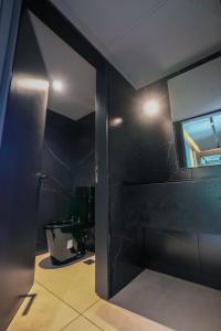 a bathroom with a black wall and a mirror at Foster Studio - Park 3 in Buenos Aires