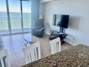 a living room with a television and a table and chairs at Ocean Walk Resort - Fabulous Ocean Front View in Daytona Beach