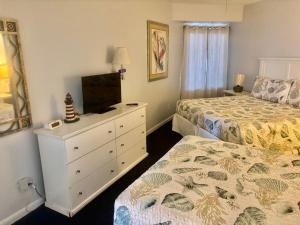 a bedroom with two beds and a dresser with a television at Ocean Walk Resort - Fabulous Ocean Front View in Daytona Beach +43 photos