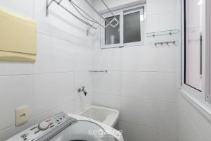 Un baño blanco con inodoro y lavabo. en Apto c/ balcón y vista al mar en Guarapari CMD0311, en Meaípe 8 fotos más