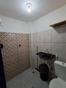 een kleine badkamer met een wastafel en een douche bij Apartamento completo Jacumã in Conde