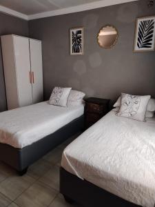 Un dormitorio con dos camas y un espejo. en Muhle Guesthouse, en Giyani