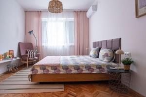 a bedroom with a bed and a chair and a window at Cozy in Varna in Varna City