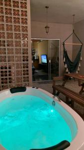 a jacuzzi tub in a room with a living room at House with Jacuzzi near São Paulo in Piracaia