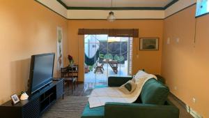 a living room with a couch and a flat screen tv at House with Jacuzzi near São Paulo in Piracaia