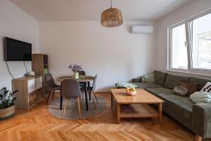 a living room with a green couch and a table at Cozy in Varna in Varna City