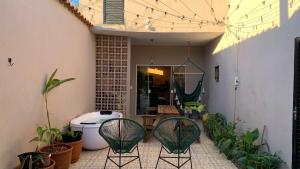 a patio with two green chairs and plants at House with Jacuzzi near São Paulo in Piracaia