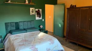 a bedroom with a bed and a green wall at House with Jacuzzi near São Paulo in Piracaia +50 photos