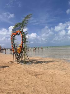 a sign on a beach with people in the water at La Palma Hostel in Maragogi +40 photos