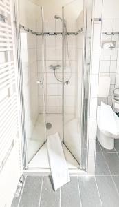 a shower stall in a bathroom with a toilet at Hotel Carlsruh in Braunlage