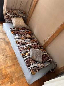 een bed met een quilt erop in een kamer bij Villatopol Art Hostel in Rząska