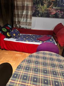 een bed in een kamer met een rode bank bij Villatopol Art Hostel in Rząska