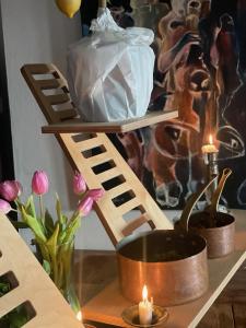een houten plank met een pot en kaarsen op een tafel bij Villatopol Art Hostel in Rząska +1 foto
