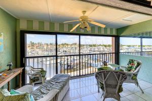 a living room with a balcony with a couch and chairs at Waterfront Views and Pool Access Punta Gorda Escape in Burnt Store Marina