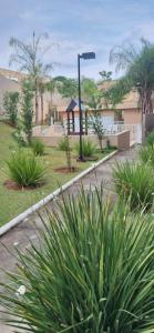 eine Straßenlaterne und einige Pflanzen in einem Hof in der Unterkunft Apartamento em Condomínio - 2 Quartos - Porto Feliz-SP- 1 Vaga in Pôrto Feliz