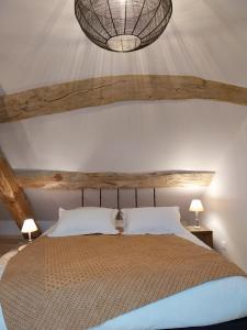 a bedroom with a large bed and a chandelier at L'Armandine in Saint-Marcel-Bel-Accueil +14 photos