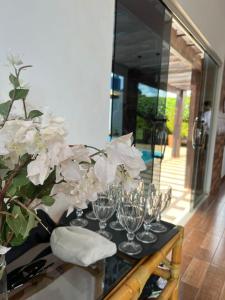 una mesa con gafas y un jarrón con flores blancas en Yãba wase, en Nobres